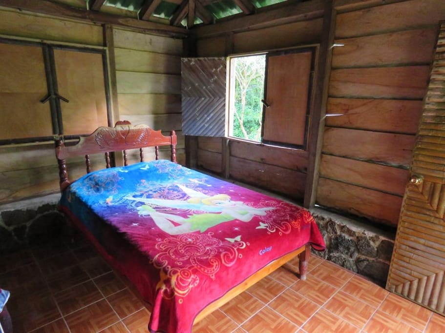 Una de la habitaciones de la cabaña rústica, con cama matrimonial, espacio para dos personas, el baño es compartido