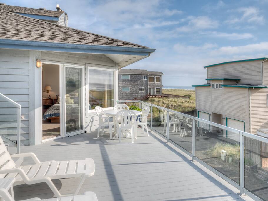Large dual level private deck off the master bedroom with patio furniture and spectacular ocean views