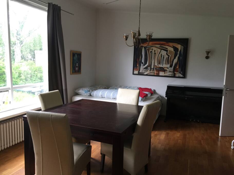 The living room with queen bed and a piano