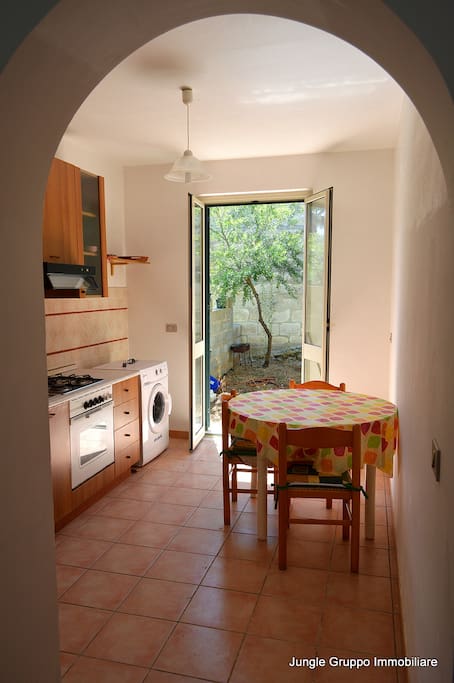 cucina con angolo lavanderia ed accesso al giardino sul retro