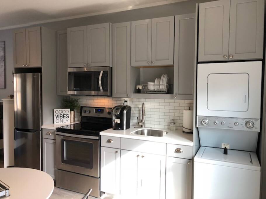 Stainless steel appliances in kitchen w/Stacked Washer & Dryer