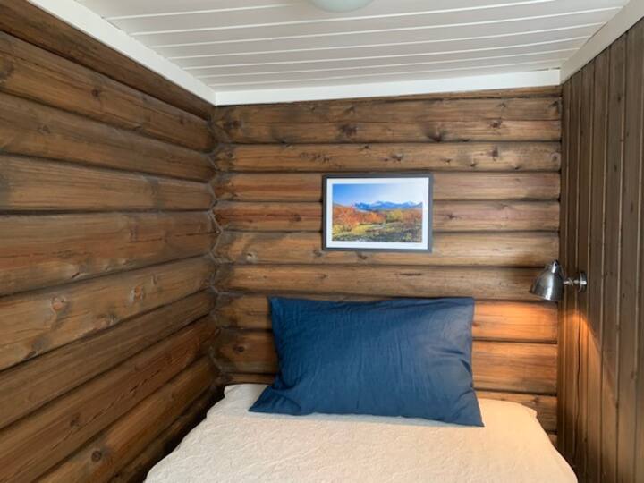 Acogedor dormitorio con troncos loft y cama doble normal de 160x200cm.