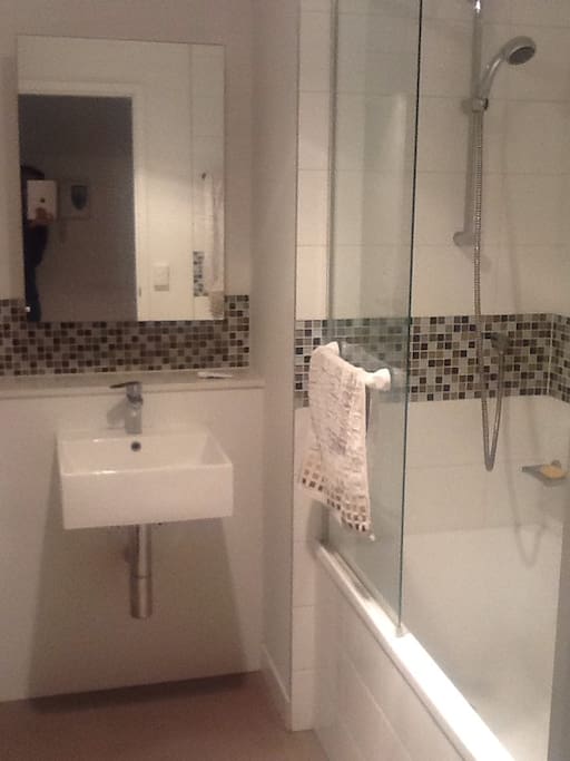 Modern bathroom facility. With bathtube and indoor loundry area.