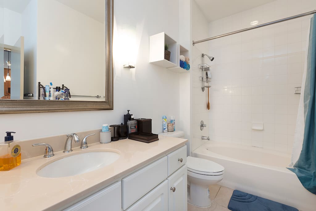 Large bathroom is super clean. All the counter space is for you. Hair dryer, iron, ironing board, towels, toiletries provided.