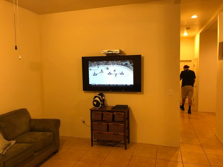 Living room with 60” HDTV, cable box with remote, PS4 Pro and VR Bundle.