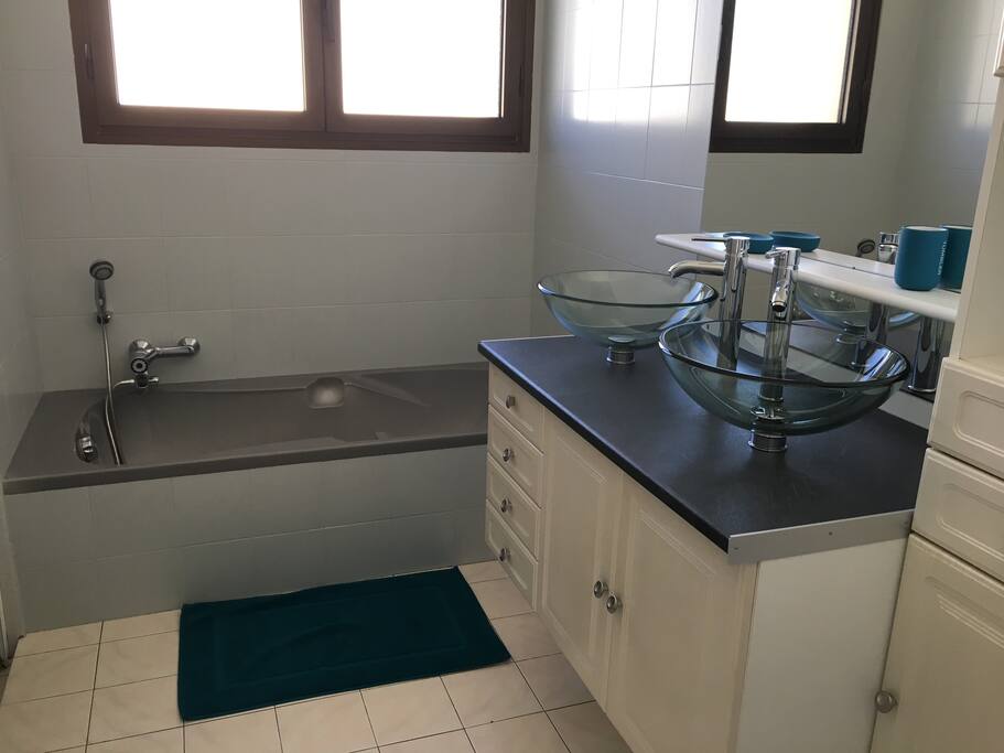 Salle de bain avec baignoire, double vasques et douche