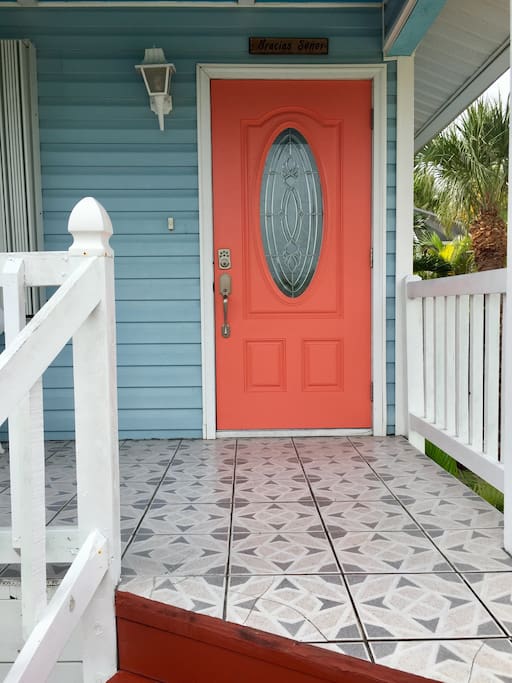 A coral colored door welcomes you