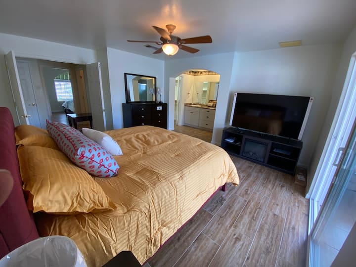 หนึ่งในสองห้องนอนใหญ่พร้อมโต๊ะเครื่องแป้งคู่ตู้เสื้อผ้าแบบวอล์คอินสมาร์ททีวีขนาด 65 นิ้วเตาผิงไฟฟ้าพัดลมเพดานห้องน้ำส่วนตัวและประตูส่วนตัวไปยังสนามหลังบ้านและสระว่ายน้ำ