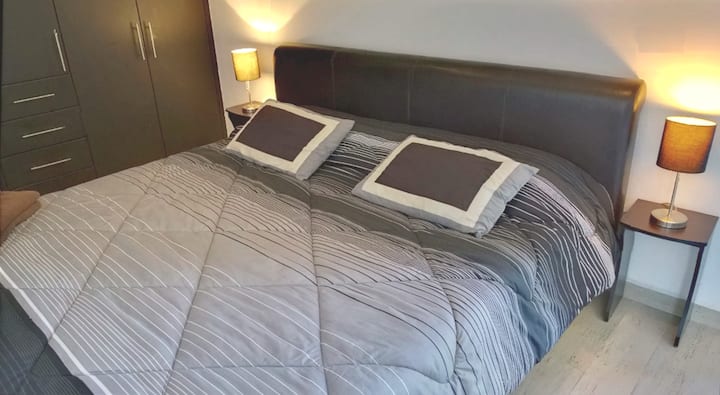 Cama tamaño king enorme con un armario enorme. 