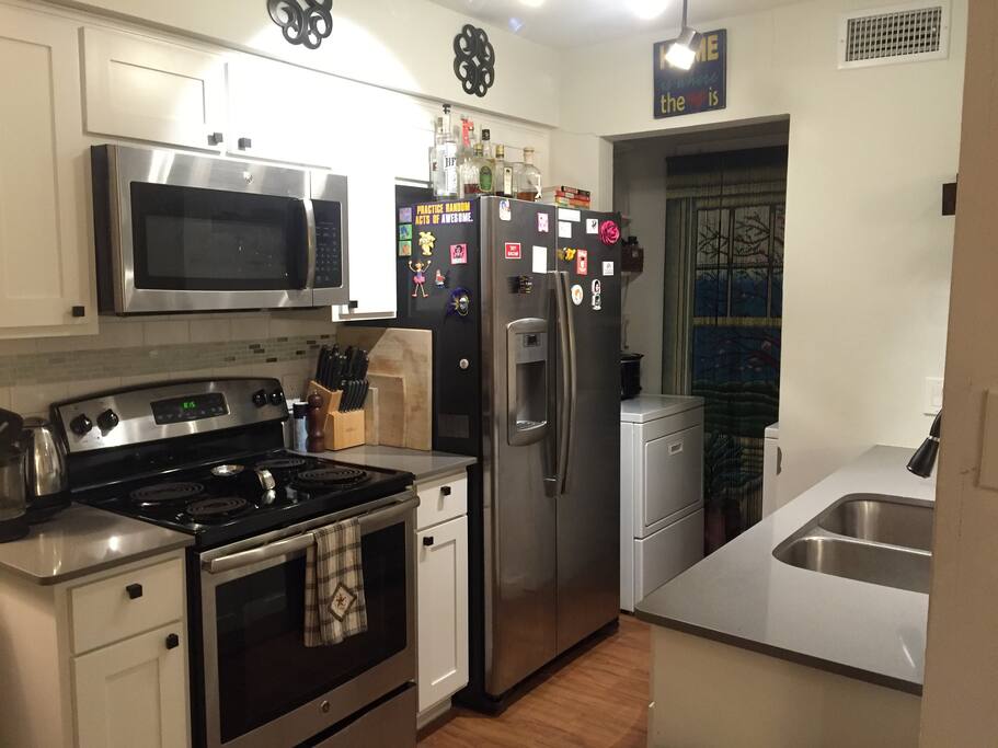 Washer/dryer room pictured in the background. Full-size kitchen pots, pans, and cooking utensils.