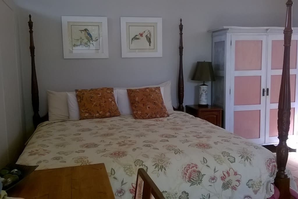 Comfortable room with desk, king bed and wardrobe.