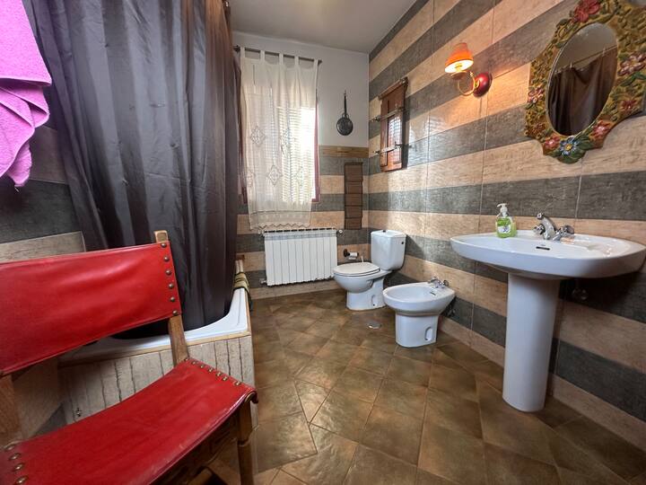 Baño completo 2 con lavabo de pie, inodoro y bidé: espacioso y con acabados en gris.