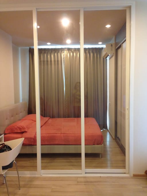 The bedroom is separated from the living room already have bed cover, air conditioner, wardrobe, and dressing table.