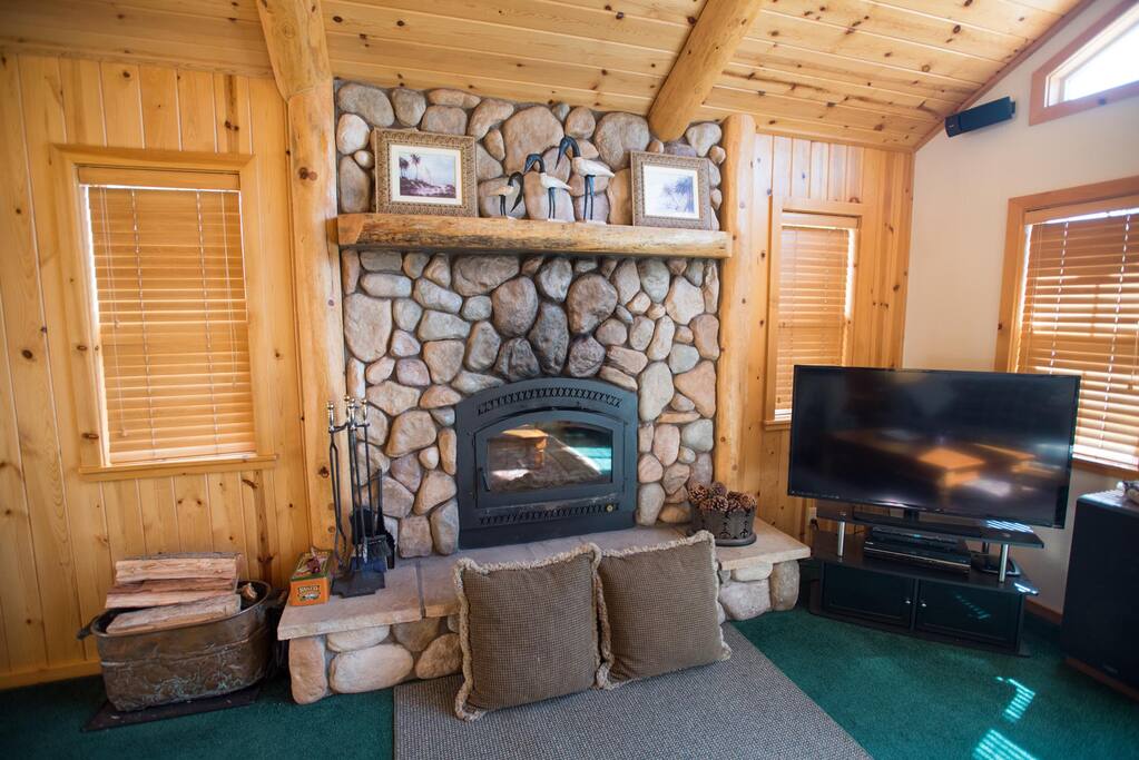 Stone fireplace in the living room with large screen TV