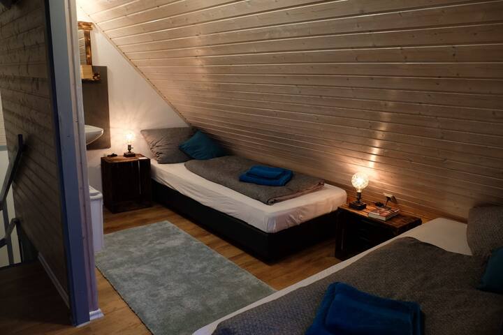 غرفة نوم في الطابق العلوي بسريرين فرديين