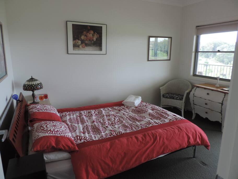 Queen bed in cosy bedroom opening up to balcony