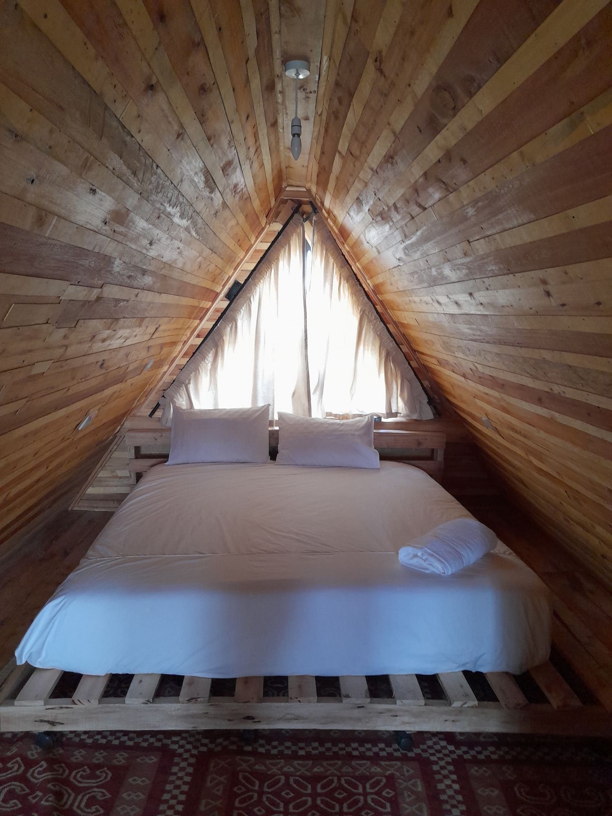 Cama tamaño king ubicada arriba para máxima privacidad y balcón personal.