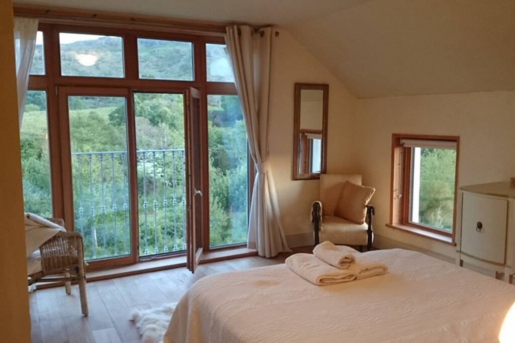 Main bedroom with king sized bed enn suite too the east and dressing area behind bed dividing wall...views are hills in all directions. Nearest house is 5minutes walk away and not visible