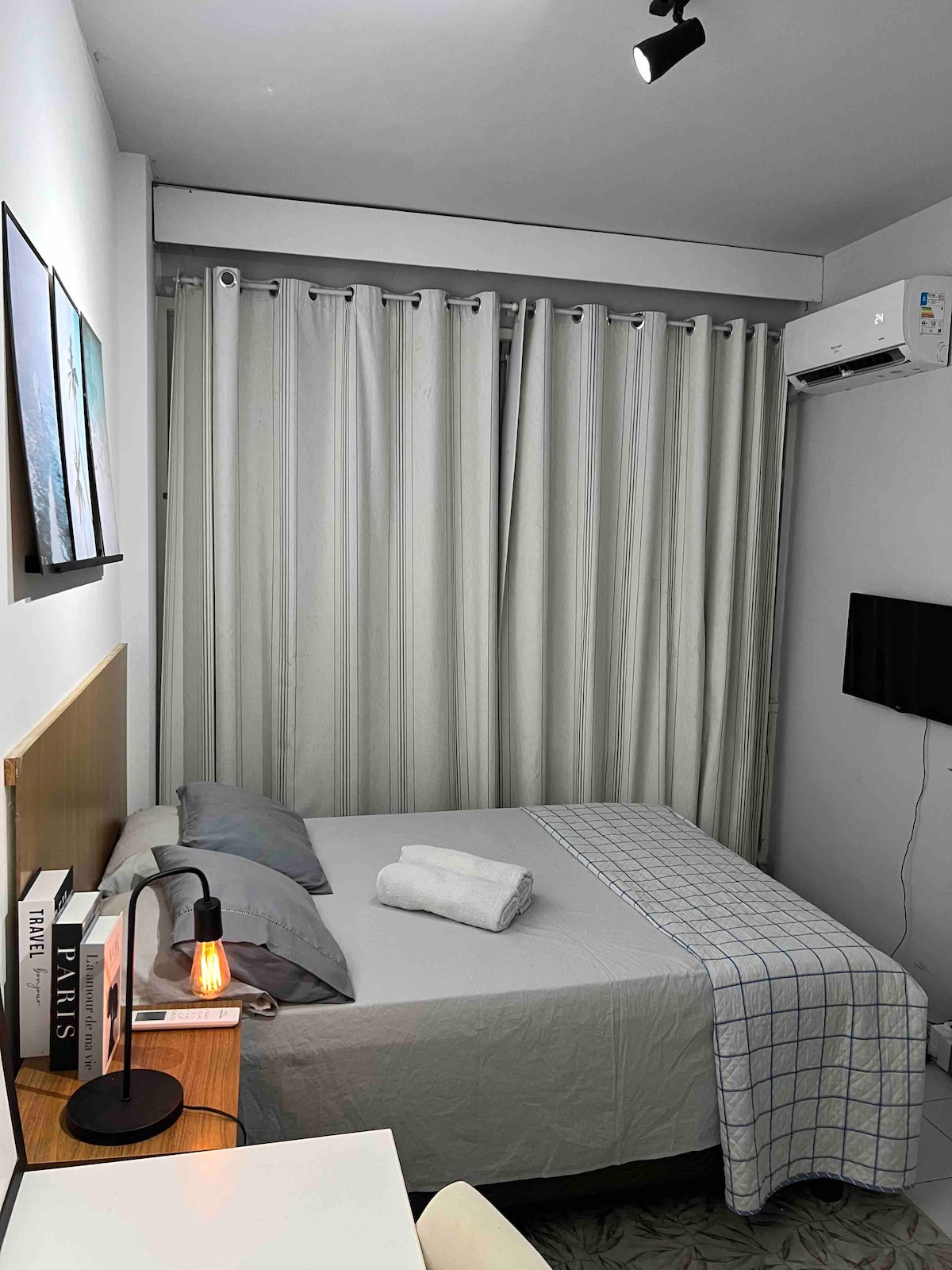 غرفة مجهزة بمكيف هواء مقسم وتلفزيون ذكي وطاولة ومصابيح بجوار السرير والمناشف 