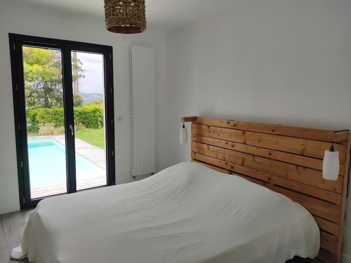 Chumba kikubwa cha kulala kilicho na bafu na mwonekano wa bwawa.