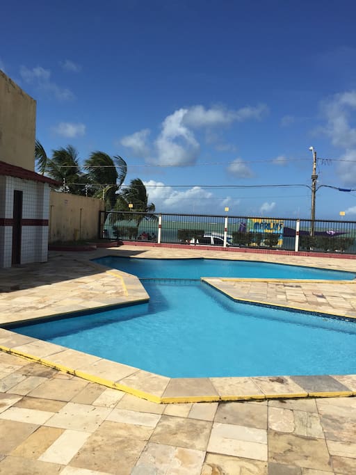 Área de lazer ampla de frente para o mar, contendo banheiros: feminino e masculino e piscina para adultos e infantil, separaras entre si por uma grade em aço inox.