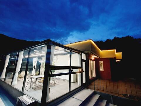 Moonlight House, a house of glass with the moon in the sky