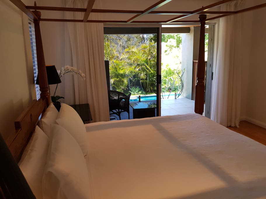 KIng four poster bed in main bedroom, has own balcony overlooking pool and tropical garden.