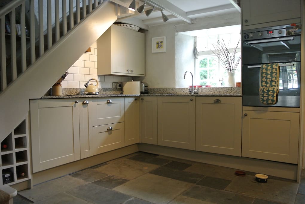 Fitted kitchen with granite worktops, hob, dishwasher, double oven and larder fridge