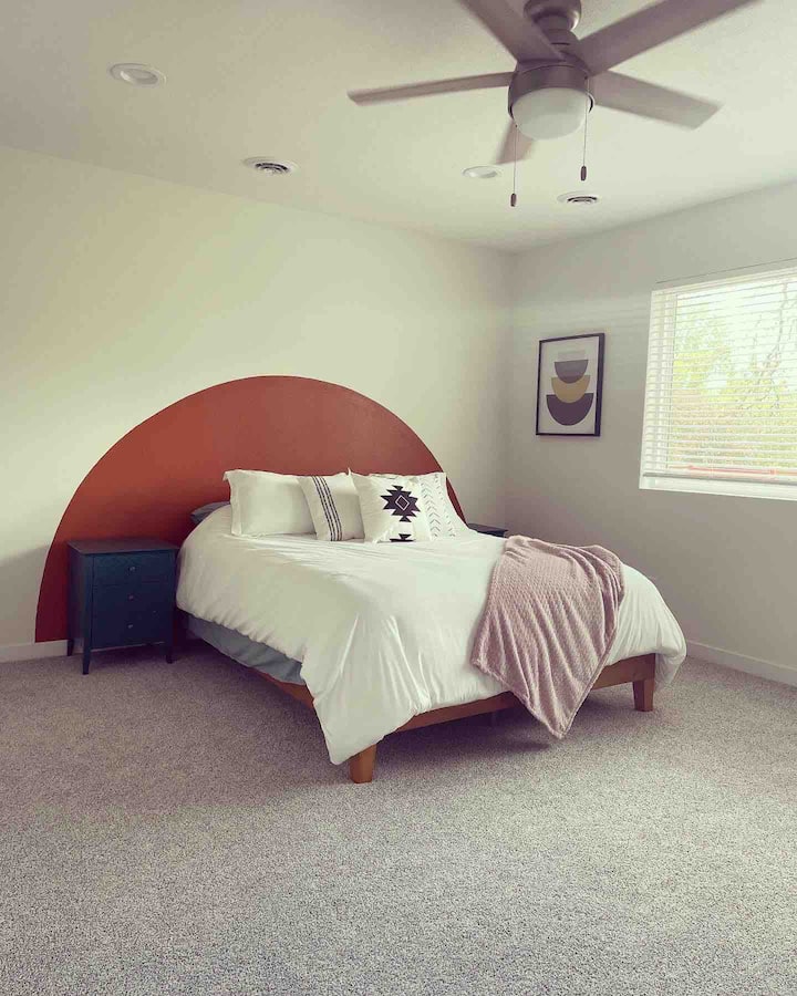 Пространа главна спална соба со сопствена бања, плакар за гости и пристап до балкон на вториот кат со поглед на езеро.