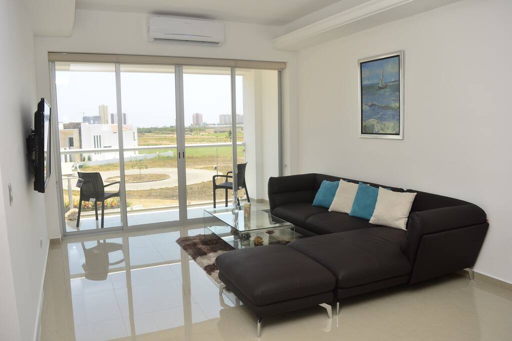 Sala tipo L con taburete y mesa de cristal templado