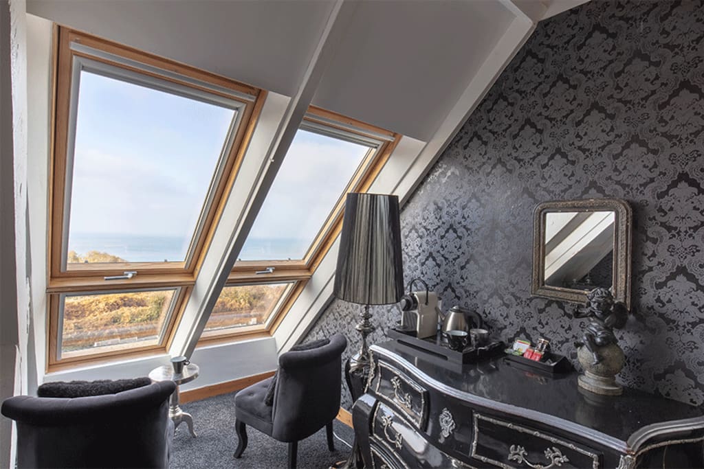 Petit salon et décoration avec vue mer depuis les fenêtre de la chambre Baccarat