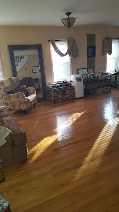 Cozy living room with open floor plan. Lots of natural light. Hardwood floors.