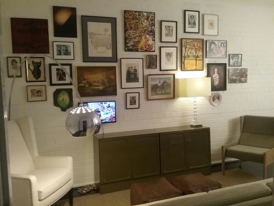 The cosy living area with TV hung amidst eclectic art.