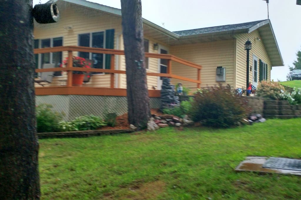 The wrap-around deck has a large patio table with 6 chairs and a gas grill.