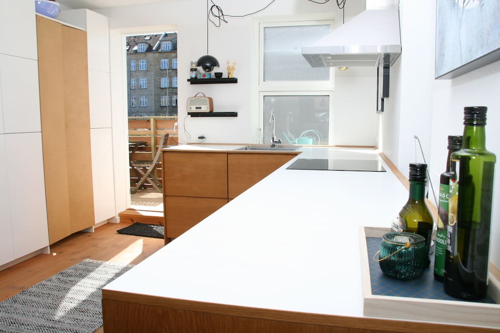 Large and bright kitchen with dishwasher, induction stove an access to laundry area.