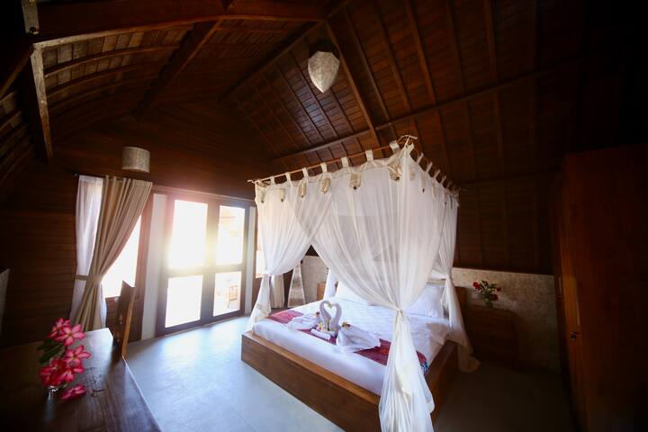 تحتوي جميع أكواخنا على غرفة نوم بمساحة 20 مترًا مربعًا مع بلاط من الجرانيت، وسرير بمقاس كبير مع مصباحين للقراءة، ومراتب أوروبية، وخزانة ملابس كبيرة، وخزانة حقيبة واحدة، ومكتب واحد مع كرسي، وثلاجة، ومصباح بالي، و9 مقابس.