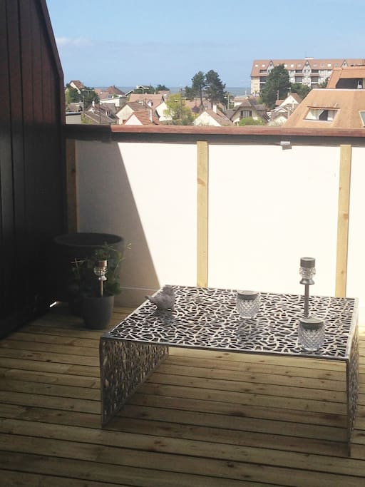 Ma jolie terrasse en bois de 9m2 où il est possible de choisir entre ombre et soleil s'illumine le soir grâce a ces lumières led qui se recharge avec le soleil permet d'entendre la mer et de manger dehors