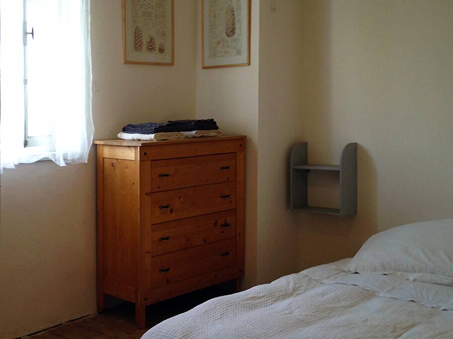 A pine chest of drawers, a window facing East flooded by sunlight in the morning.