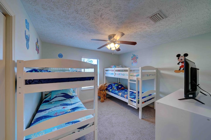 غرفة أطفال بسريرين بطابقين وتلفزيون وحامل بألعاب متعددة للأطفال