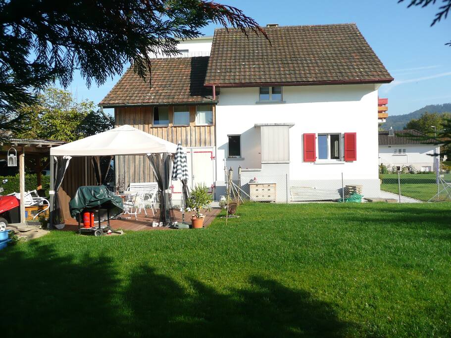 Westseite mit privatem Grill- und Sitzplatz mit Spielwiese
