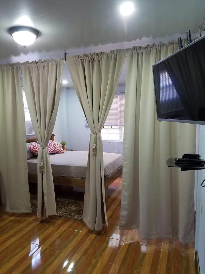 Drapes drawn to show the bedroom with cozy bed.  