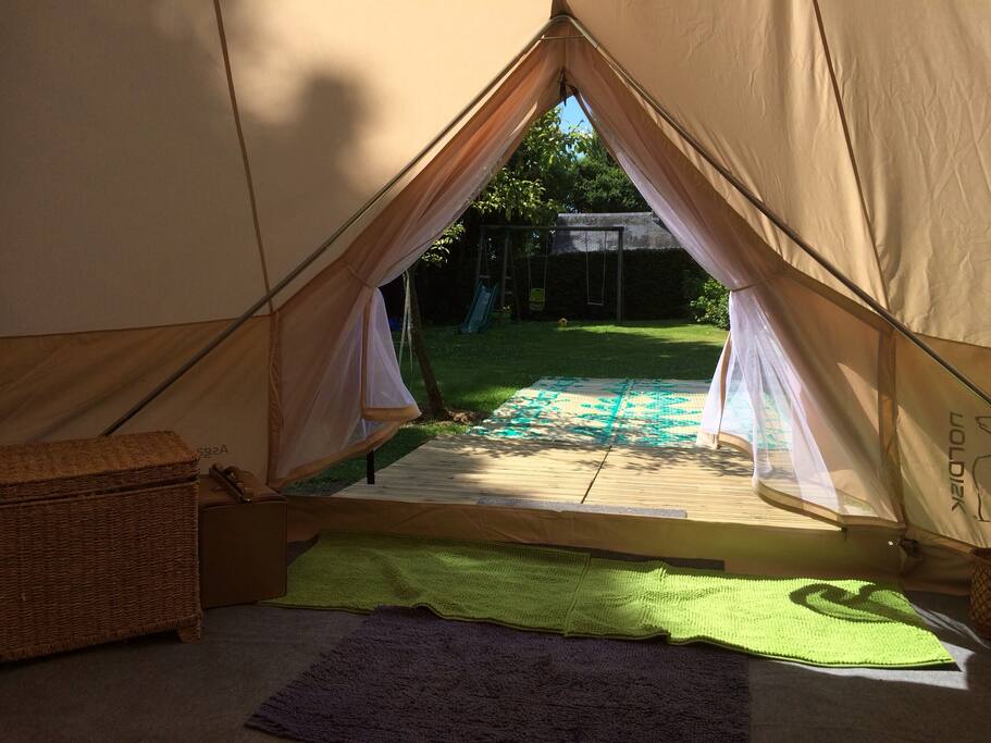 Vue du lit sur le jardin .terrasse en bois et tapis de jardin