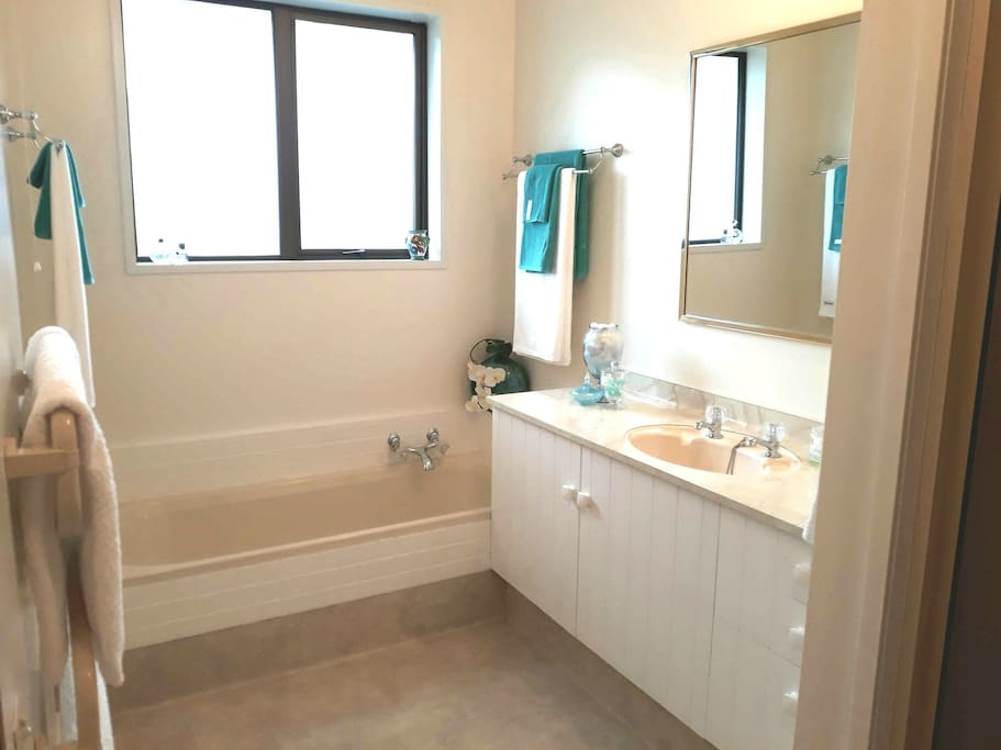 Spacious bathroom with shower and bath and a range of toiletries provided.