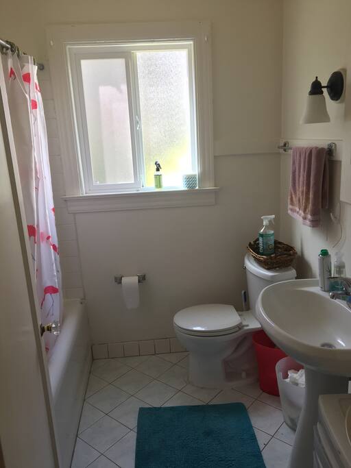 Shared bathroom with tile floors and shower/bathtub.