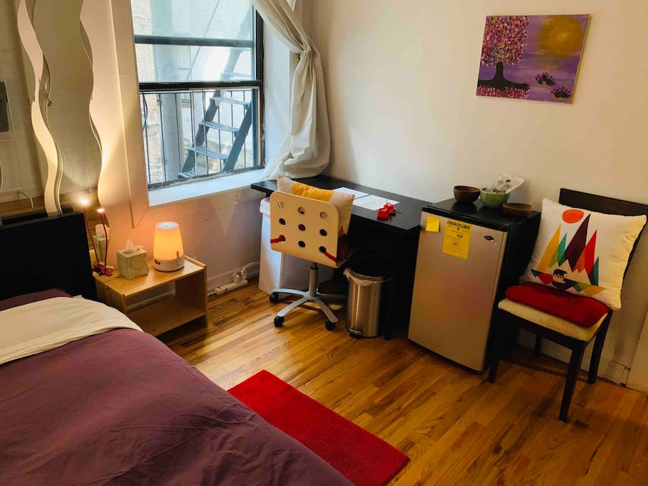 The bedroom includes a desk and a mini-fridge.
