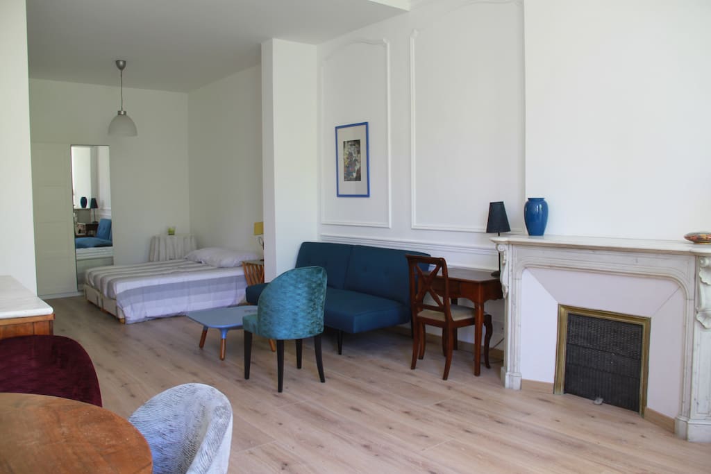 Le séjour depuis le coin repas qui mène à la cuisine. L'appartement est situé dans un ancien hôtel particulier très calme et vient d'être refait à neuf. Il donne sur les jardins.