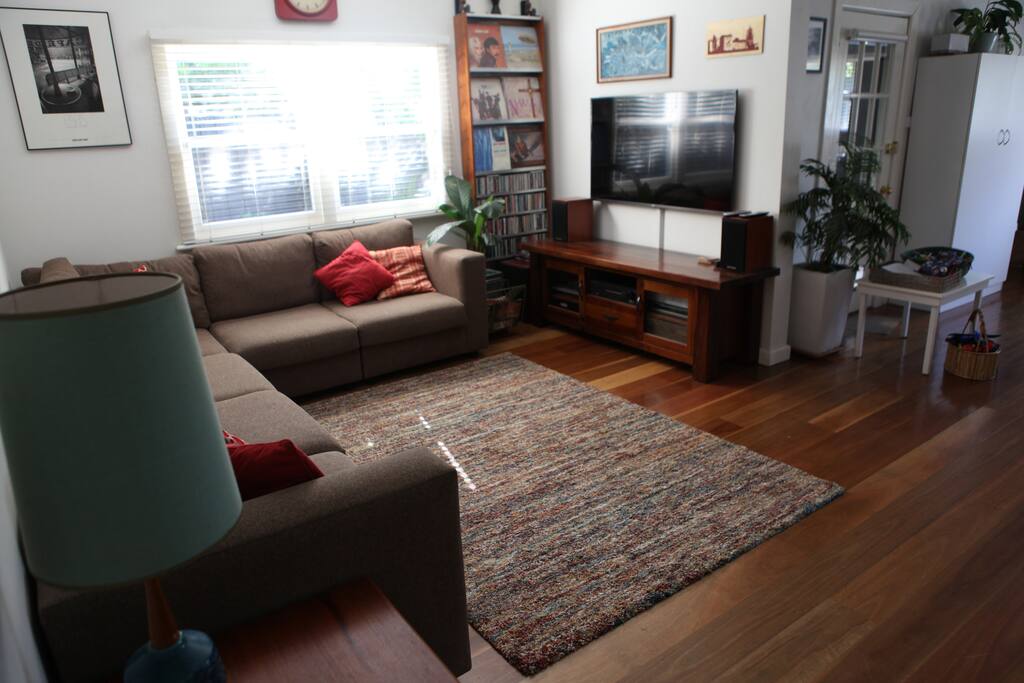 Open-plan living area with large couch and smart TV.