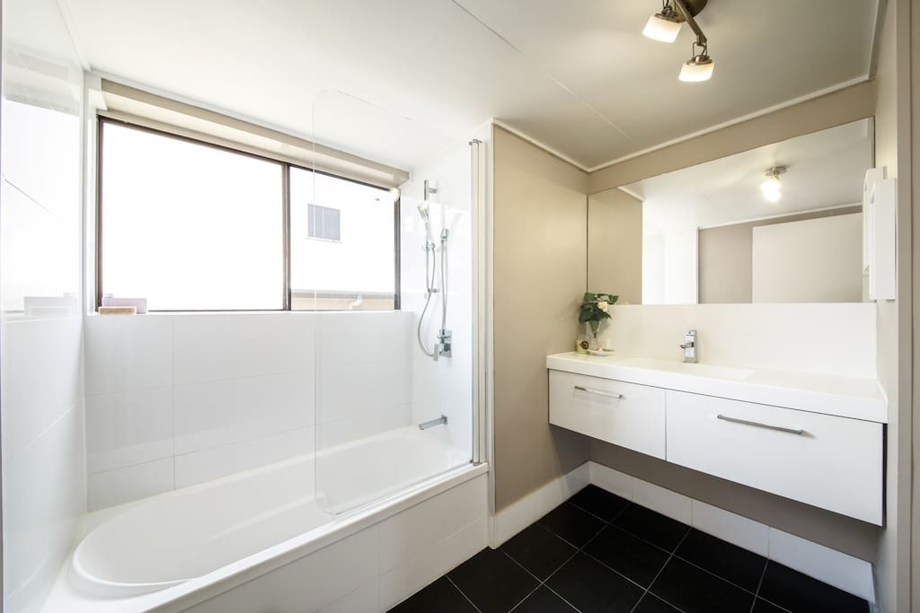 Modern, clean and airy bathroom with hidden laundry.