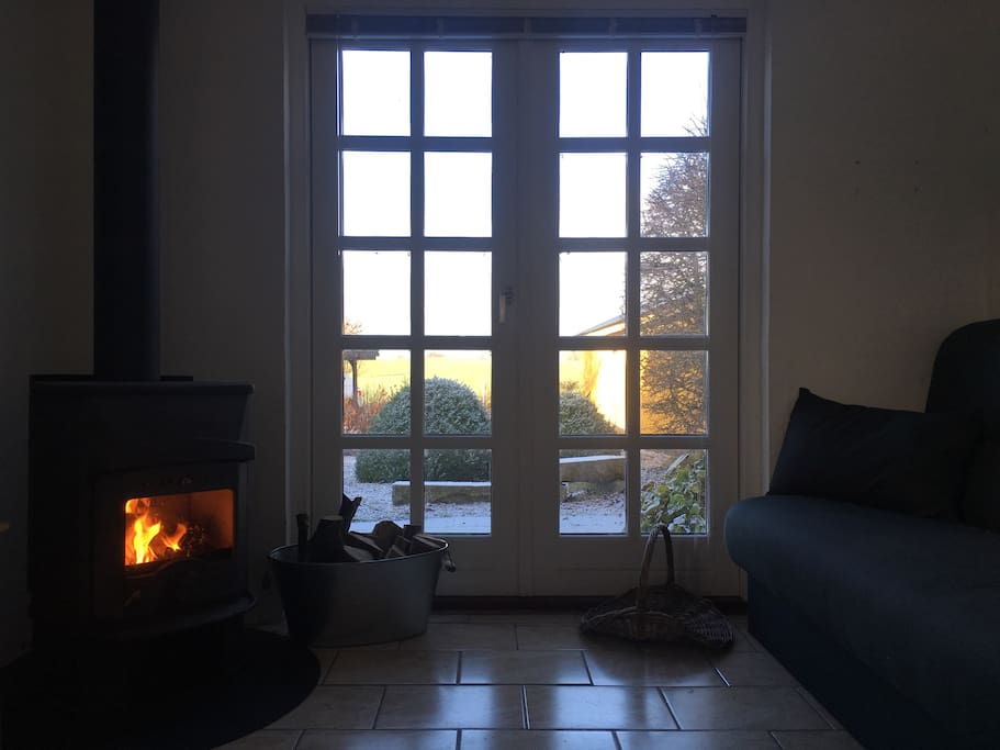 Brændeovnen og udsigten fra sovesofaen // The fireplace and the view from the sofabed