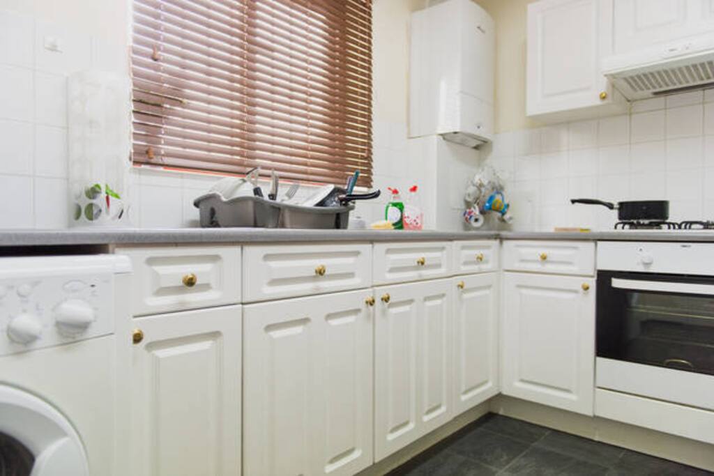There is a washing machine and lots of storage space